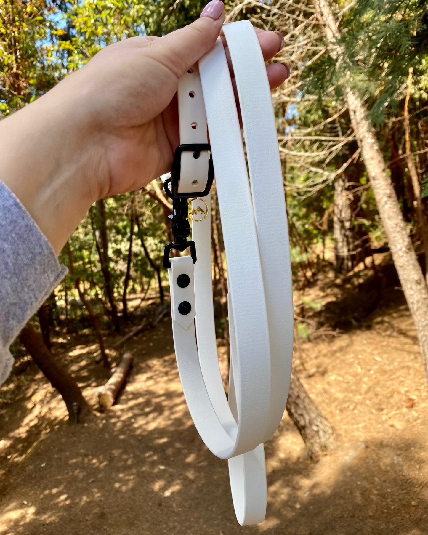 Arctic White classic dog leash being held by a person in the woods. 