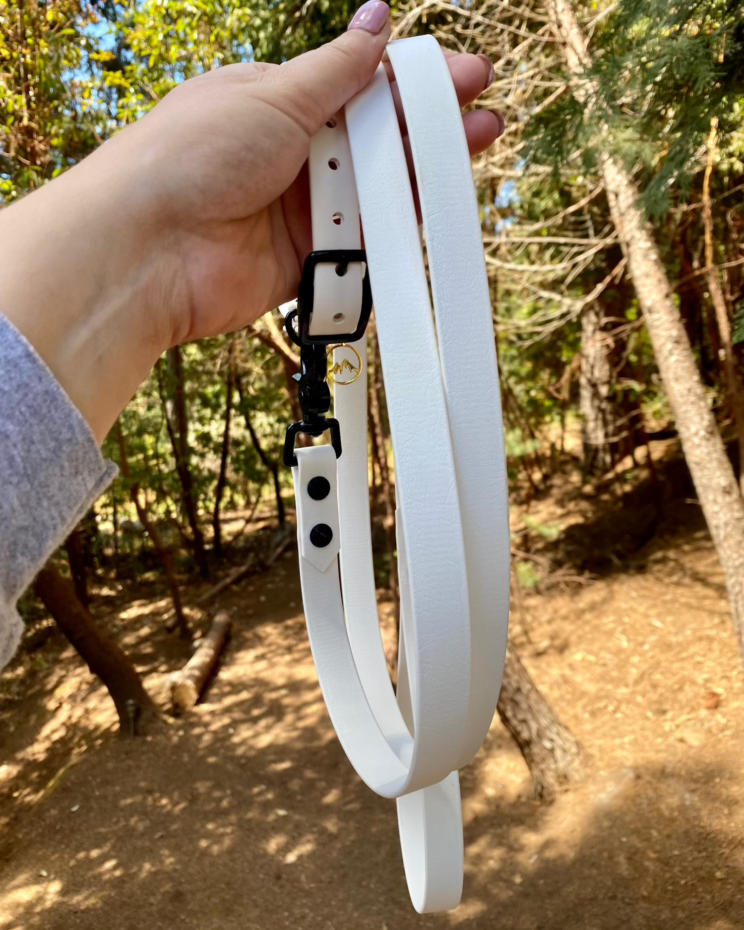 Arctic White classic dog leash being held by a person in the woods. 